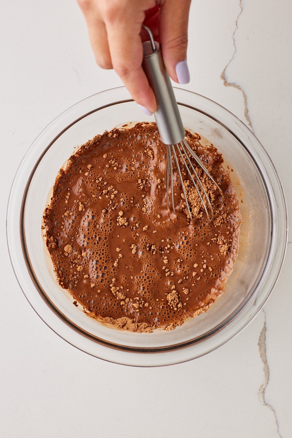In a large bowl, whisk together the hot water and cocoa powder. 