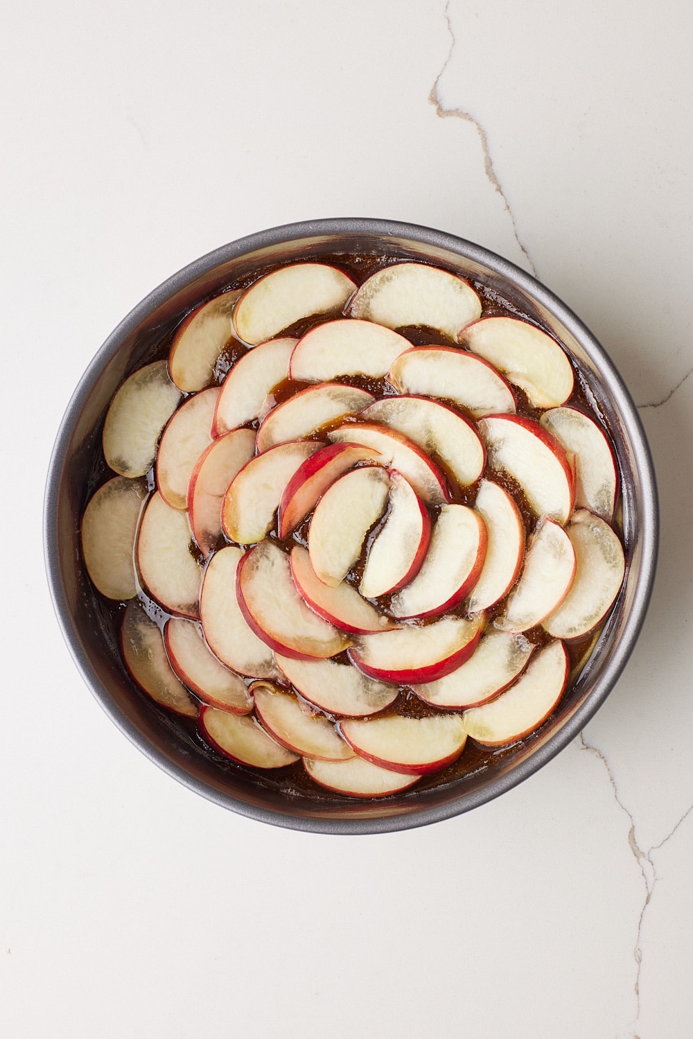 Arrange the peach slices in a tight circular pattern over the brown sugar syrup, starting from the center and working outward.