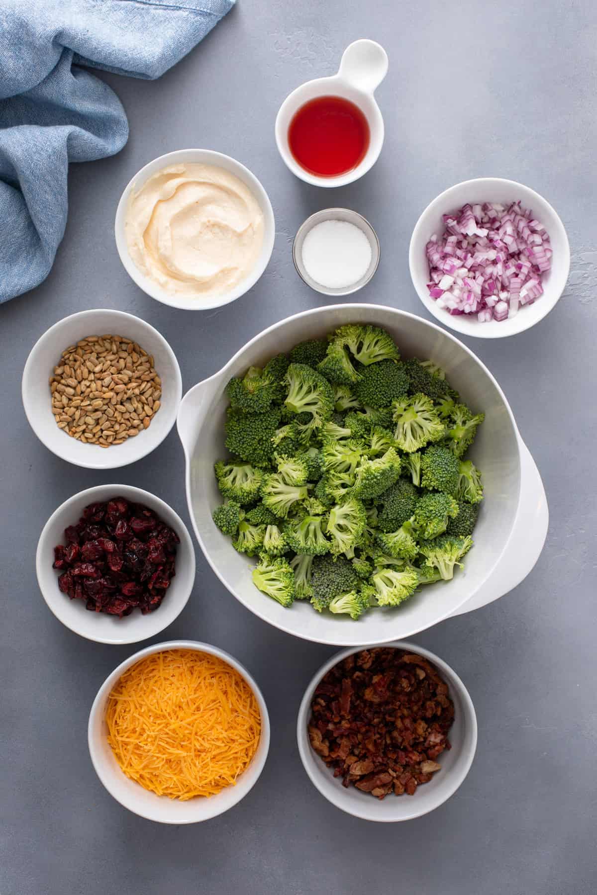 Ingredients for broccoli cranberry salad arranged on a countertop.