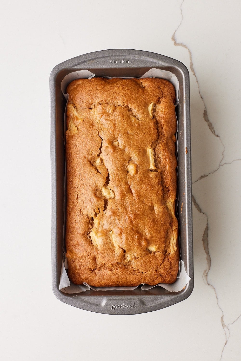 Top-down view of Apple Loaf Cake baked gold brown in the tin. 