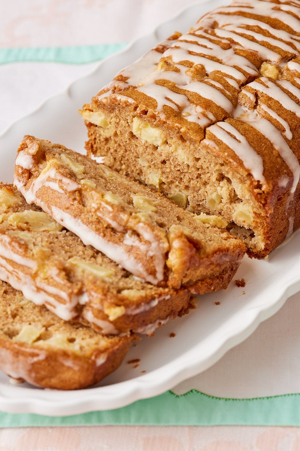 A close-up shot at sliced Apple Loaf Cake showing its most crumb loaded with apples and drizzled with glaze. 